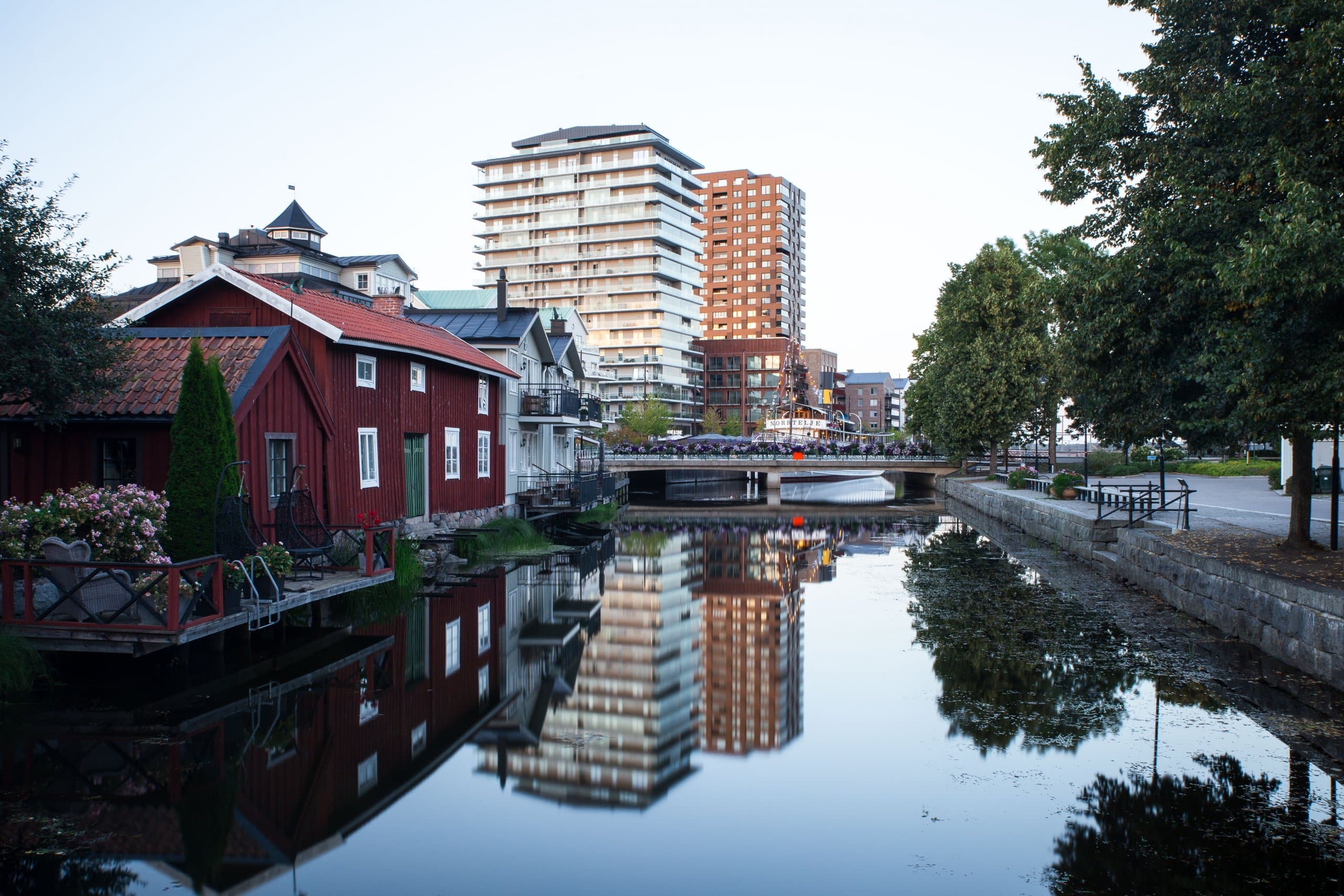 Kväll över Norrtäljeån. Byggnader och vatten.